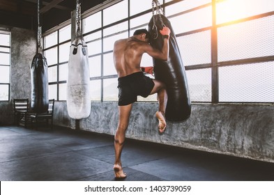 Muay Thai Fighter Training In The Gym With The Punch Bag