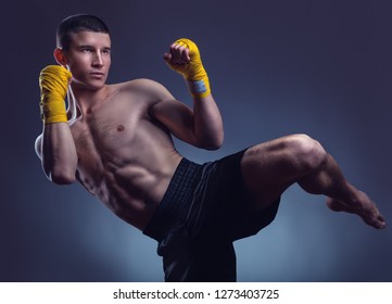 Muay Thai Or Kickboxer Executing A Powerful Kick Against Black Background