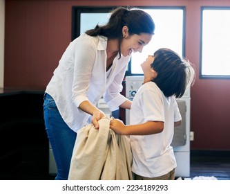 Its so much fun when you help me. Cropped shot of a young attractive mother doing laundry with her son at home. - Powered by Shutterstock