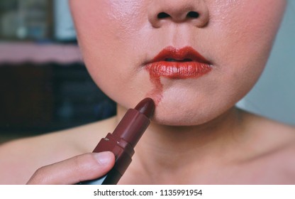 Too Much Makeup Concept, Woman Apply Red Lipstick On Mouth And Color On Chin