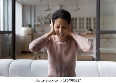 Too much noise. Anxious young hispanic woman shout stop cover ears with palms unable to hear loud music noisy sound. Angry frustrated millennial female get mad hate listening disturbing noise indoors