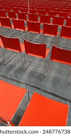 much red chairs in rows side by side from backside.