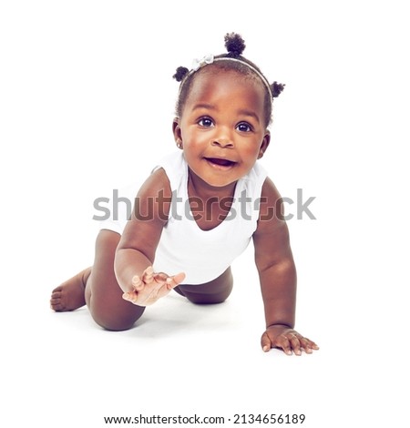 So much to see.... Studio shot of a baby girl crawling against a white background.