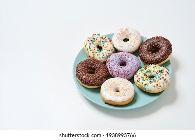 Too Much Sugar. Freshly Baked Various Delicious Colourful Round Glazed Donuts With Sprinkles On The Plate Over White Background, Copy Space For Text. Unhealthy Eating, Dieting And Junk Food Concept