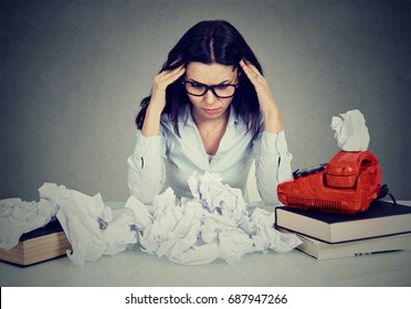 Too Much Work Stressed Woman Sitting At Her Disorganized Desk With Books And Many Paper Balls Isolated On Gray Office Wall Background. 