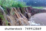 Mud and flowing water reach a pond / swamp during heavy rain looks like water fall causing soil erosion with wave and splash