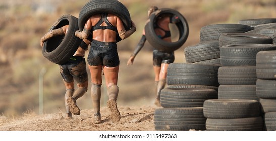Mud race runners. Runners carrying tires in a test of the race