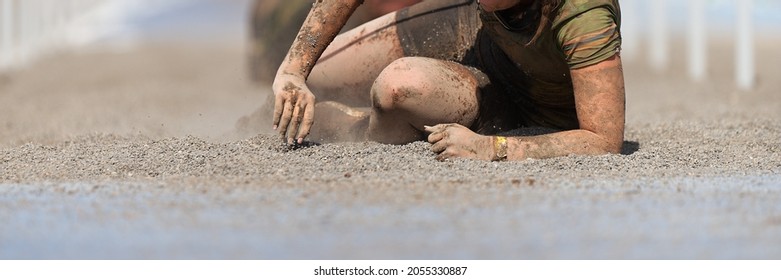 Mud Race Runners. Crawling, Passing Under A Wire Obstacles During Extreme Obstacle Race