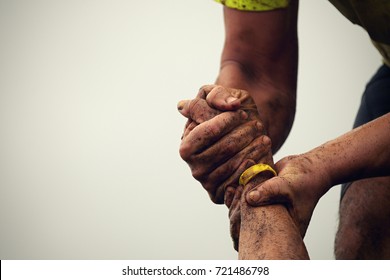 Mud race runners.Couple hold hands,help when overcoming hindrances mud - Shutterstock ID 721486798