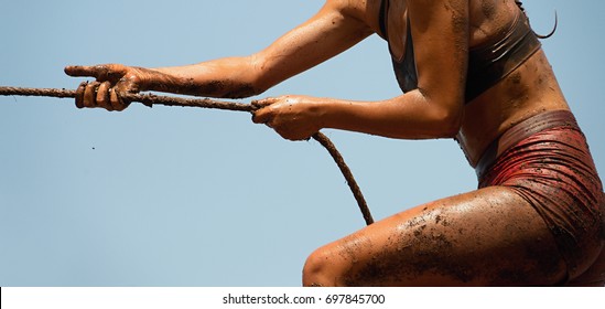 Mud race runners,defeating obstacles by using ropes