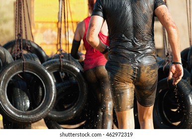 Mud race runners,overcoming barriers on hanging tires - Powered by Shutterstock