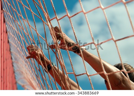Mud race runners.Woman lying on the net