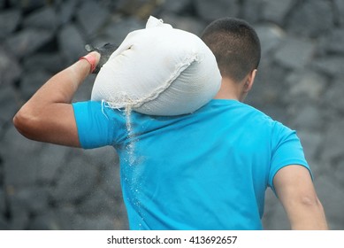 Mud race runners,young man carrying tear sandbag