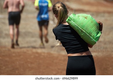 Mud Race Runners,young Woman Running With Sandbag