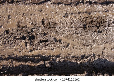 Mud Texture Or Wet Brown Soil As Natural Organic Clay And Geological Sediment Mixture. Road Bog After The Rainy Season Found.