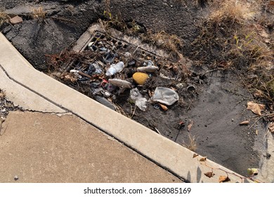 Mud And Trash In A Storm Drain Beside A Clean Sidewalk, Pollution, Horizontal Aspect