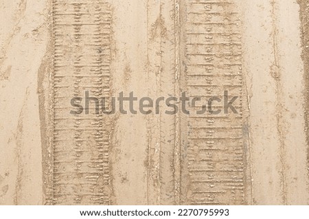 Mud tyre mark background. Wet sand tire print texture. Ttrail track pattern.Metal excavator track background. Construction site sandy ground. House building background. Heavy machinery equipment.