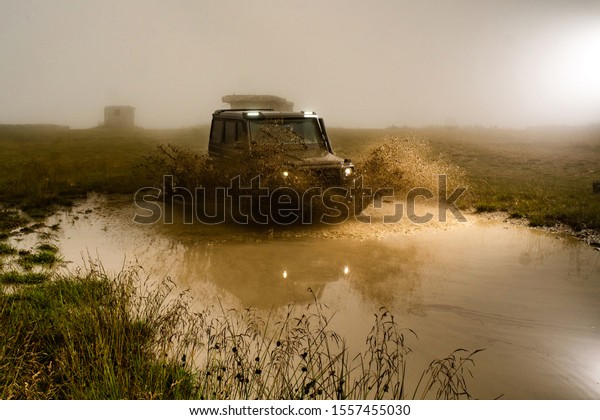 Mud and water splash in off-road racing. Off road\
car. Beautiful nature. Truck car wheel on offroad steppe adventure\
trail