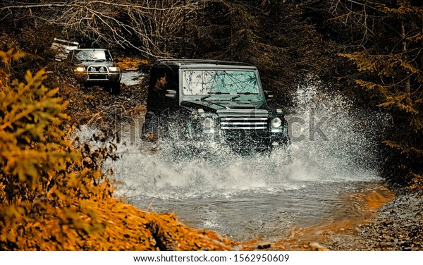 Mud and water splash in\
off-road racing. Off road sport truck between mountains landscape.\
Expedition offroader. Tracks on a muddy field. Road adventure.\
Adventure travel