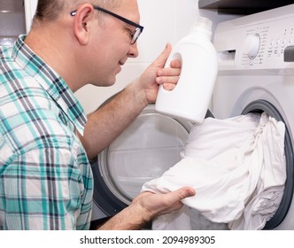 Mudchina, a Caucasian, middle-aged, pours bleach into the washing machine for washing clothes. - Shutterstock ID 2094989305