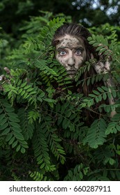 Muddy Amazon Brown-haired Girl Hiding Behind A Bush In The Woods