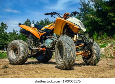 Muddy Atv Parked On Dirty Road