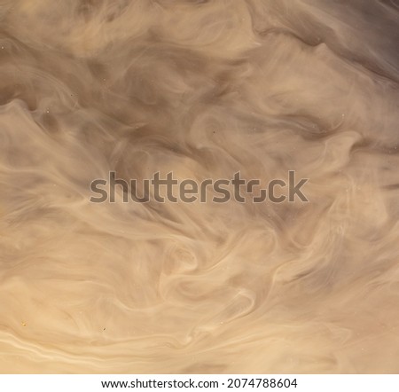 Muddy brown water in a puddle as an abstract background.