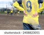muddy football field with muddy player, detail of an unrecognizable player