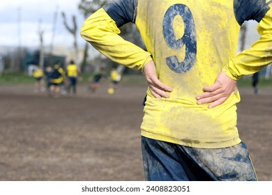 muddy football field with muddy player, detail of an unrecognizable player - Powered by Shutterstock