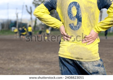 muddy football field with muddy player, detail of an unrecognizable player
