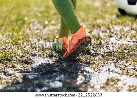 Muddy Football Field. Player Walking On Muddy Soccer Pitch. Soccer Cleats Covered With Mud and Dirt