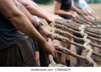 muddy hands holding a rope together - Powered by Shutterstock