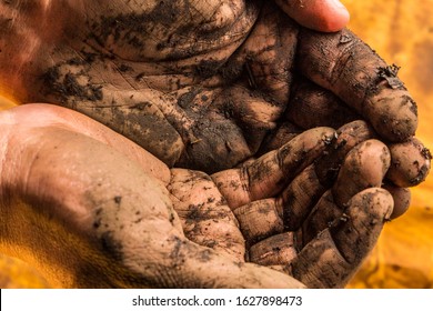 Muddy hands on yellow background