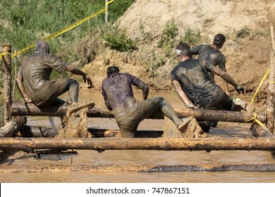 Muddy Obstacle Race Runner In Action. Mud Run
