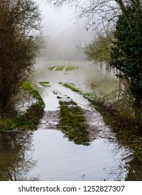 Muddy wet road going through a field