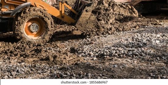 Muddy Wheels Of An Excavator Bulldozer Truck Working On A Construction Site