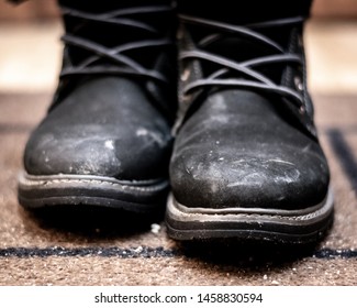 Muddy Winter Shoes On A Door Mat In Apartment Indoors