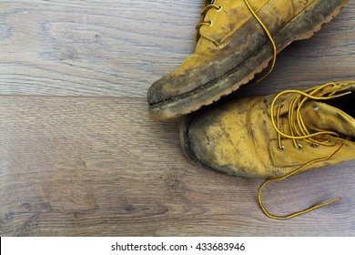 Muddy Work Boots On A Wooden Floor