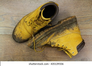 Muddy Work Boots On A Wooden Floor