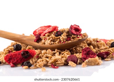 Muesli cereals close up with  raisins, oat and wheat flakes, fruits, strawberry, cranberry, cherry pieces. Isolated on white. In wooden spoon