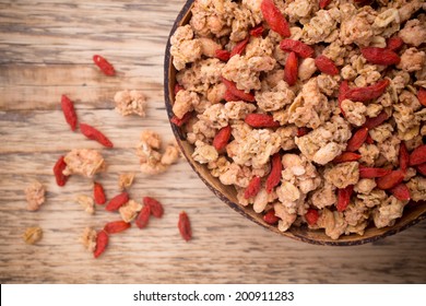 Muesli with goji berries in a bowl on a wooden background. - Powered by Shutterstock