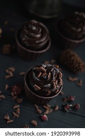 Muffin or cupcake with chocolate shaped cream at black table. Flatlay top view