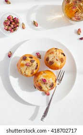 Muffin, Mini Cake, Cup Cake On A White Plate With A Rose Buds Tea On A White Textile Background Top View