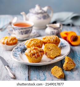 Muffins, Peach Fruit Cupcakes With Cup Of Tea. Blue Wooden Background. Close Up.