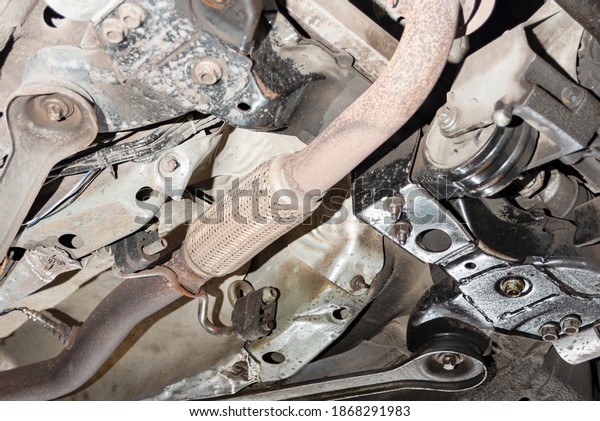 Muffler, resonator of the exhaust\
system under the car at the service station, bottom\
view.