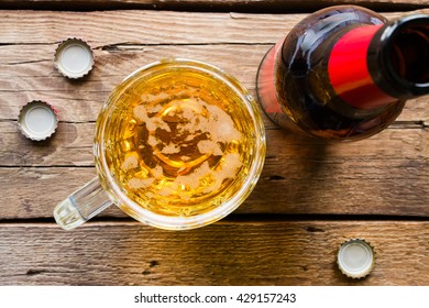 Mug Of Beer And A Bottle On A Wooden Background Top View