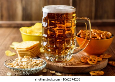 Mug of beer and snacks on wooden background. Selective focus. - Powered by Shutterstock