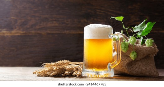 mug of beer, wheat ears and green hops on wooden background - Powered by Shutterstock