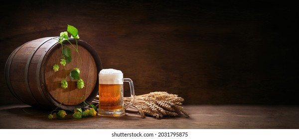 Mug Of Beer, Wheat Ears, Hops And Beer Barrel On A Wooden Background