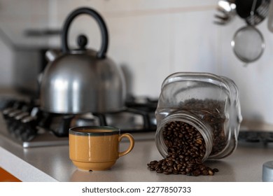 Mug for brewing fresh coffee on the kitchen counter. A coffee pot and a metal kettle on a gas stove in the background. - Powered by Shutterstock